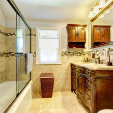 Nice bathroom with natural stone tiles and wood cabinet.