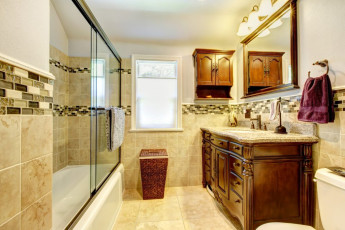 Nice bathroom with natural stone tiles and wood cabinet.